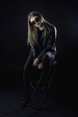 genç kız bir siyah deri ceket ve güneş gözlüğü üzerinde karanlık bir ba