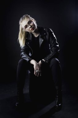 genç kız bir siyah deri ceket ve karanlık bir backg gözlük