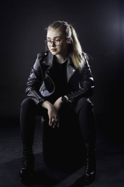 genç kız bir siyah deri ceket ve karanlık bir backg gözlük