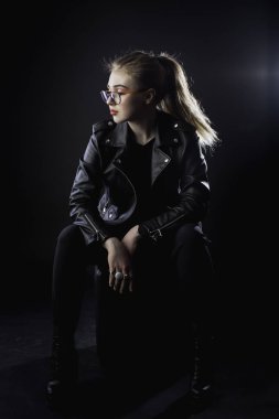 genç kız bir siyah deri ceket ve karanlık bir backg gözlük