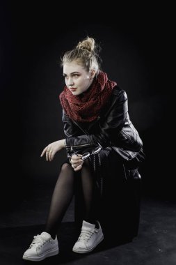 s karanlık bir arka plan üzerinde siyah deri ceketli genç kız