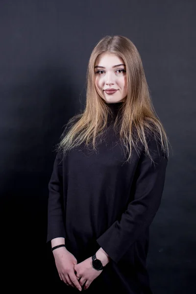 Retrato de una joven con un vestido negro sobre un fondo oscuro — Foto de Stock