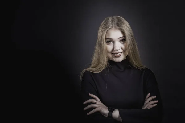 Egy fekete ruhás, sötét háttér előtt egy fiatal lány portréja — Stock Fotó