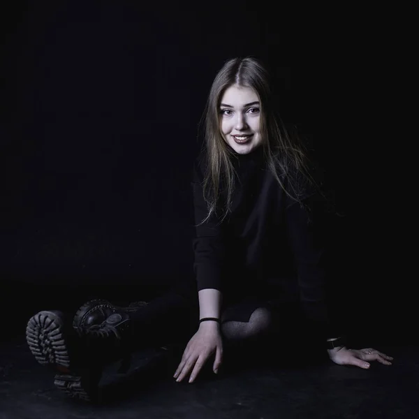 Fiatal lány, egy fekete ruhás, sötét háttér előtt a stúdióban — Stock Fotó