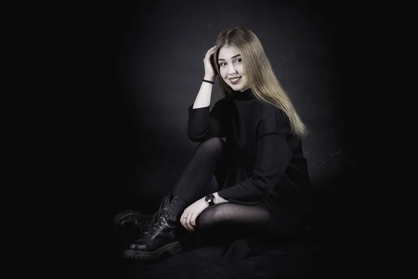 Young girl in a black dress on a dark background in the studio — Stock Photo, Image