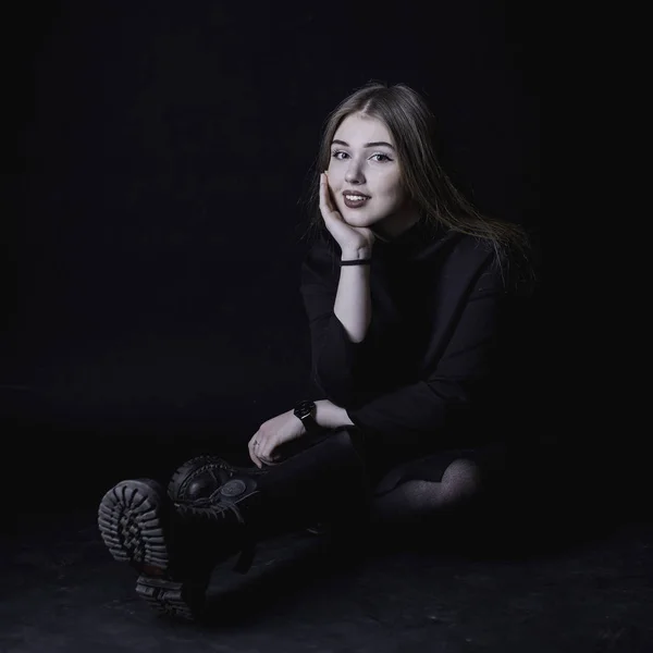 Chica joven en un vestido negro sobre un fondo oscuro en el estudio — Foto de Stock