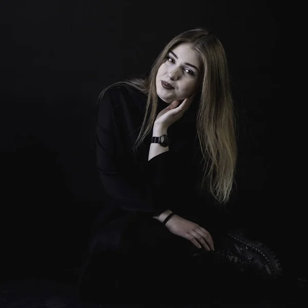 Young girl in a black dress on a dark background in the studio — Stock Photo, Image