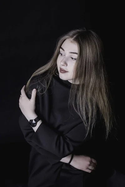 Молодая девушка в черном платье на темном фоне в студии — стоковое фото