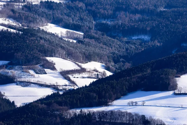 stock image Scenic and idyllic color image of an Austrian rural winter landscape with snow, hills,valley,trees, road and farm buildings