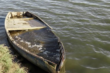 bir nehir bankada eski ahşap tekne battı