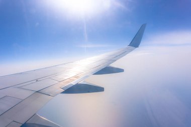 Uçak penceresinden görünümü okyanus mavi, güneşli gün. Tatil kavramı