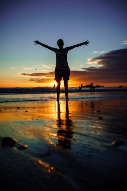 Kadın sunset Beach, Yalı açık kollarına kızla silüeti. Özgürlük kavramı