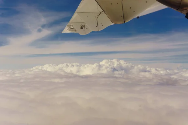 飛行機輸送概念 左翼の旅客機で表示します 太陽に照らされた厚い雲 水平方向の表示 — ストック写真