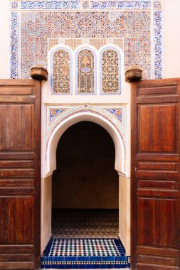 Girişinde kemer olan ve Fas 'taki geometrik mozaiklerle süslenmiş bir binanın dikey fotoğrafı.