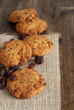 Çuval bezi bez ve koyu ahşap arka plan çerezleri ve kuru üzüm dikey Üstten Görünüm