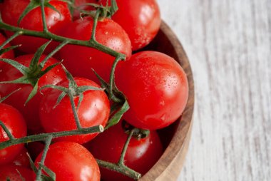 Beyaz ahşap zemin üzerinde kırmızı kiraz domates ahşap kase Üstten Görünüm