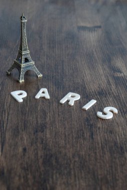 Kopya alanı ile koyu ahşap arka plan üzerinde harfler ile Eyfel Kulesi mockup dikey üst görünümü 