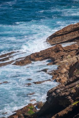 Kuzey İspanya'da kayalık kıyıya karşı dalgalar ile dikey manzara