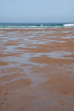 İnsanlar olmadan düşük gelgit plaj Dikey manzara. Cobreces, Cantabria, İspanya, Avrupa'da bulutlu bir bahar günü