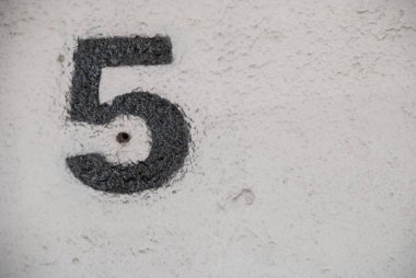 Kopyalama alanı olan beyaz bir duvara siyaha boyanmış beş numara