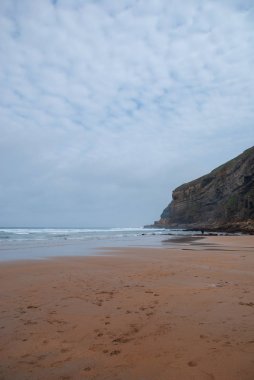 Arka planda düşük gelgit ve uçurum ile plaj Dikey manzara Cobreces bulutlu bir sabah, Cantabria, İspanya, Avrupa