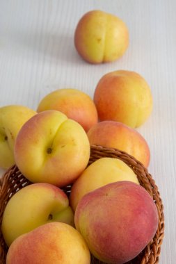 Beyaz ahşap arka planda sepette kayısı yakın çekim