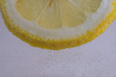 Kopya alanı ile beyaz arka plan üzerinde kabarcıklar ile suda limon Dilim