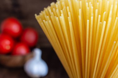 Domates ve sarımsak odaklanmamış arka plan ile ham spagetti yakın çekim