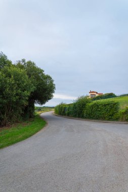 Ev, çayır ve ağaçlar, Cantabria, İspanya, Avrupa gün batımında bulutlu bir öğleden sonra ile Yerel yol