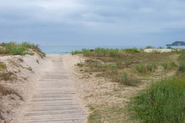 Cantabria, İspanya, Avrupa arka planda plaj ve bulutlu gökyüzüne ahşap yol