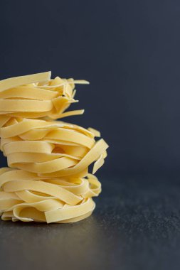 Kopya alanı ile siyah arka plan üzerinde dikey fettuccine makarna yakın çekim
