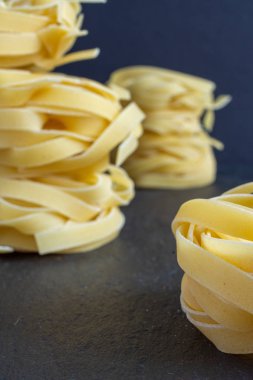 Fettuccine yığını ile makarna yakın çekim kopya alanı ile siyah arka plan geri defocused