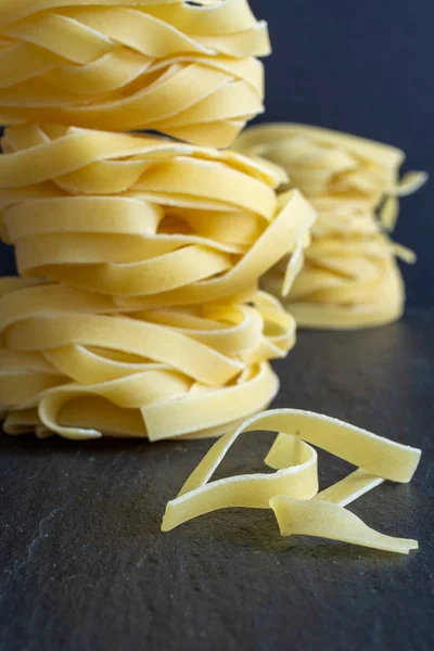 Close Pasta Pile Fettuccine Defocused Posterior Black Background Vertical — Stock Photo, Image