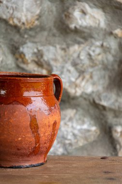 Odaklanmamış taş arka plan üzerinde ahşap masa üzerinde kil pot yakın çekim