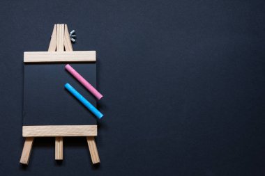 Mavi ve pembe tebeşirile siyah bir arka plan üzerinde şüskül şeklinde boş bir tahta havadan görünümü