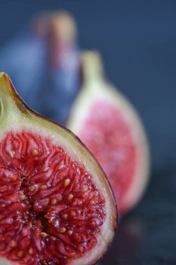 Siyah arkaplanda kırmızı bir incirin makro yakın plan görüntüsü, bokeh etkisi ile