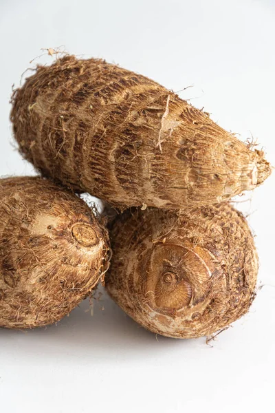 Dikey olarak beyaz arkaplan üzerine kahverengi malanga yakın plan