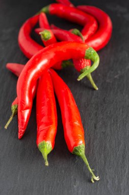 Siyah arkaplanda kırmızı biberlerin üst görünümü, arkaplandakiler odak dışı