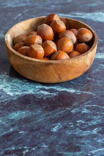 Top View Hazelnuts Wooden Bowl Blue Marble Background Vertical — 스톡 사진