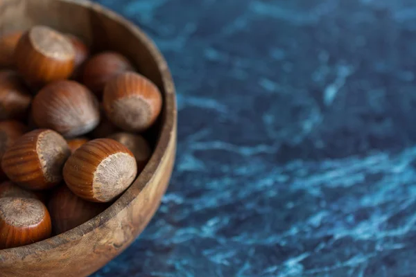 Close Hazelnuts Wooden Bowl Blue Marble Background Copy Space — 스톡 사진