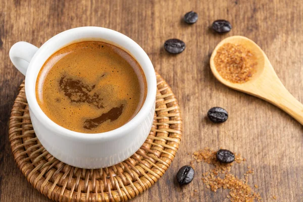 コーヒーカップの空中ビュー 木製のテーブルの上に茶色の砂糖とコーヒー豆と木製のスプーン — ストック写真