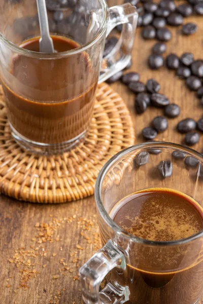 コーヒー豆と木製のテーブルの上にコーヒーと2つのガラスカップのトップビュー 選択的フォーカス — ストック写真