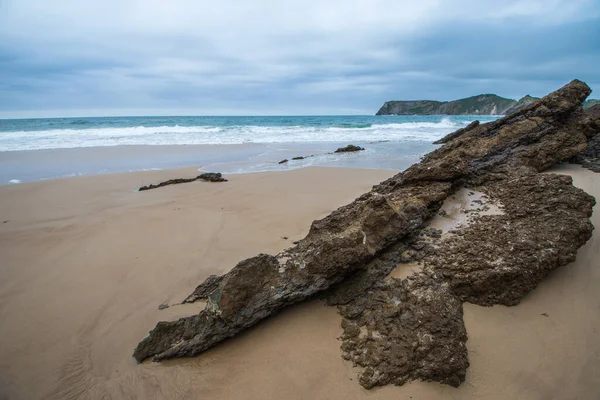 Plážová Krajina Horninou Popředí Zamračené Odpoledne Namodralými Tóny Comillas Cantabria — Stock fotografie
