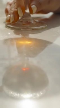 Dikey video. Havuz kenarındaki ıslak masaya dairesel ışık yansıması, sanatsal odak, havuz kenarı estetiği.