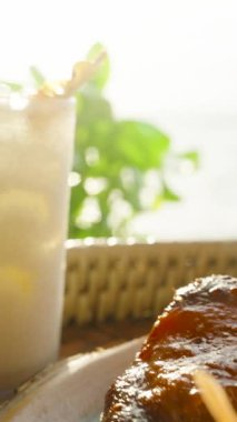 Dikey video. Kızarmış tavuk budu, papaya salatası ve soğuk limonata. Arka planda deniz var. Yakın plan, geleneksel Tayland Gıda Konsepti.