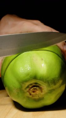 Dikey video. Taze Yeşil Papaya 'yı Kesen Ellerin Kapanışı Tahta Bıçakla Siyah Arkaplanda Görünür Görünür Görüntü Bulanıklığı Sağlıklı Yeme kavramından Ele Geçirildi