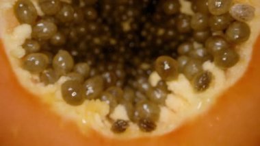 Yakın çekim Dolly, Papaya Dilimlerinden geçerken Bıçak, Parlak Turuncu Et ve Parlak Tohumlar ile Merkez Tohum Mağarasına doğru kesiliyor. Meyve Hazırlama Süreci kavramı.