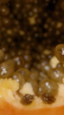 Dikey video. Yakın çekim Dolly, Papaya Dilimlerinden geçerken Bıçak, Parlak Turuncu Et ve Parlak Tohumlar ile Merkez Tohum Mağarasına doğru kesiliyor. Meyve Hazırlama Süreci kavramı.