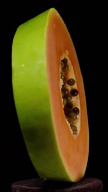 Dikey video. Siyah Arkaplan 'da izole edilmiş Yeşil Derili Papaya Dilimi ve Merkez Tohum Kabuğu, Egzotik Meyve Tazeliği ve Beslenme Konsepti