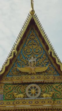 Dikey video. Mavi Gökyüzü Açısına Karşı Karmaşık Örnekler ve Efsanevi Figürlerle Süslemeli Altın Tapınak Cephesi, Wat Plai Laem Samui Kültür Mirası Konsepti